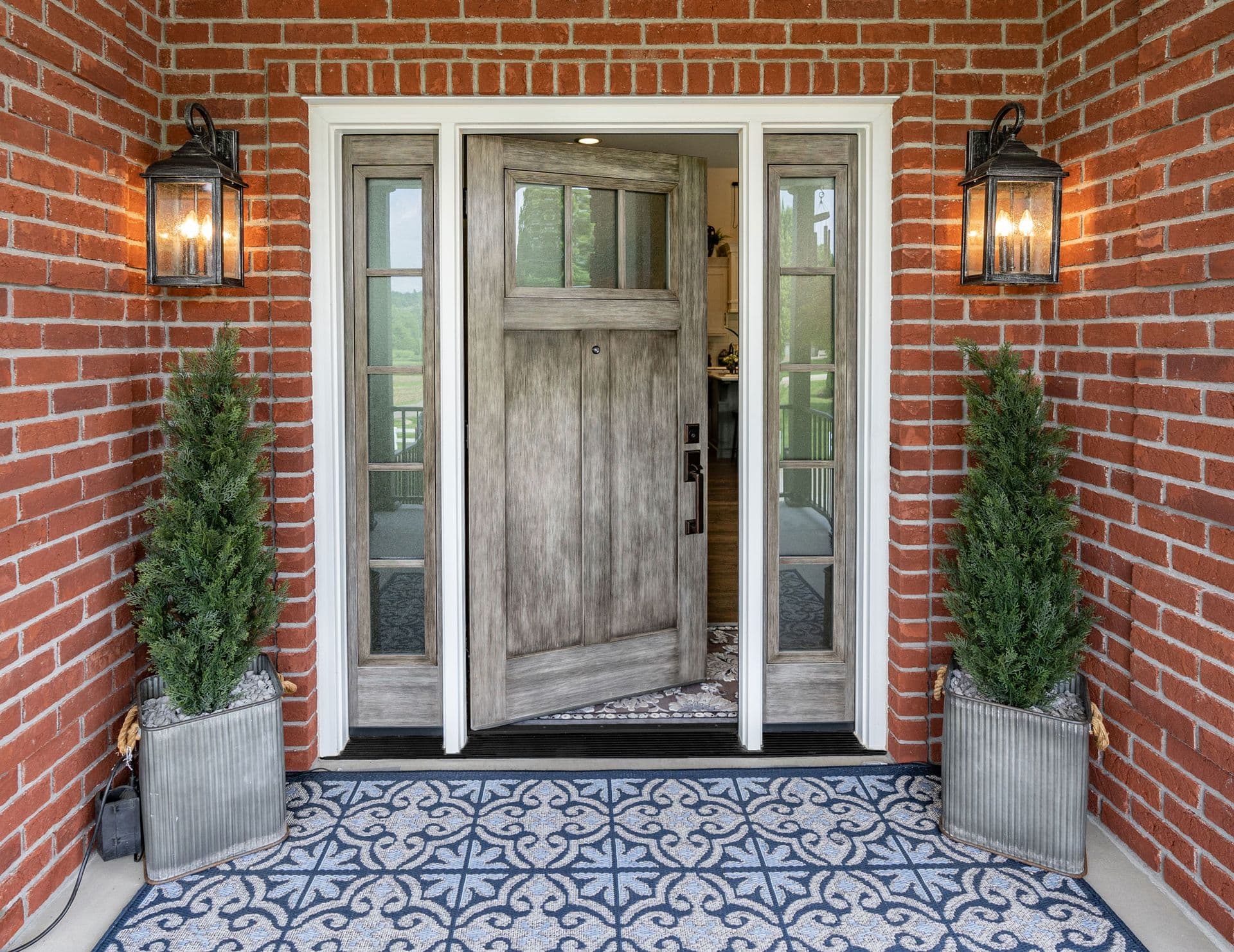 Light brown/grey entry door with brick siding